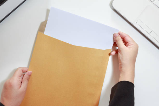 geschäftsfrau hält das leere papier in hülle - opening mail letter envelope stock-fotos und bilder