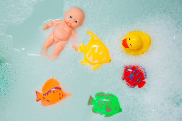 Bath toys in white foam bubbles closeup