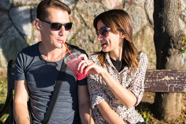 istock Beautiful couple with sunglasses having fruit smoothie 641655958