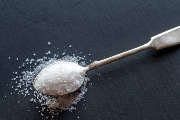 istock Spoon with white sugar on the dark background 641657132