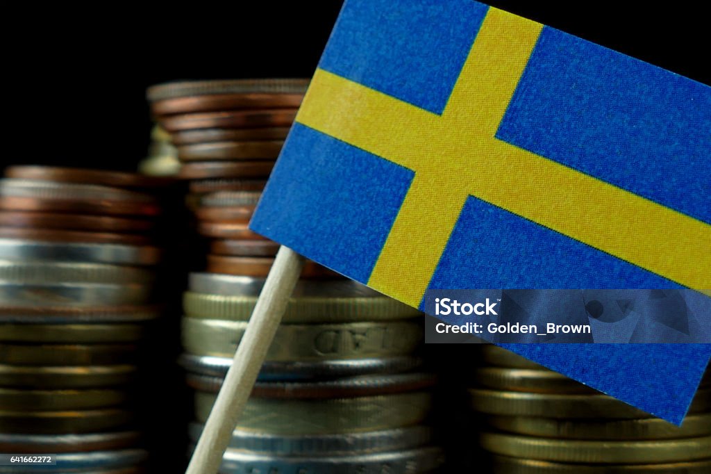 Bandera de Suecia ondeando con pila de dinero monedas macro - Foto de stock de Actividades bancarias libre de derechos