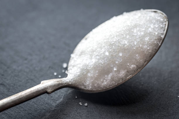 istock Spoon with white sugar on the dark background 641664210