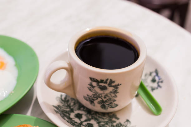 Fractal on the cup is generic tradition Chinese print, no license required.Oriental Chinese Black coffee in vintage mug and Original bread toast with kaya a local jam made from eggs, sugar and coconut milk.
