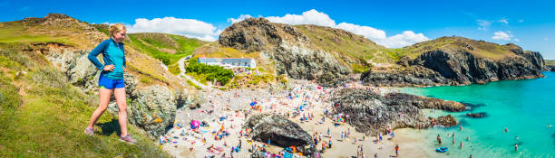 istock Woman trail runner on cliff overlooking summer holiday beach panorama 641667246