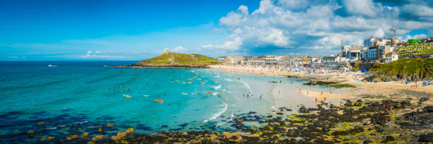 Surfers and sunbathers on sandy beach St Ives panorama Cornwall