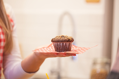 Women holding a serving of freshly baked chocolate muffin