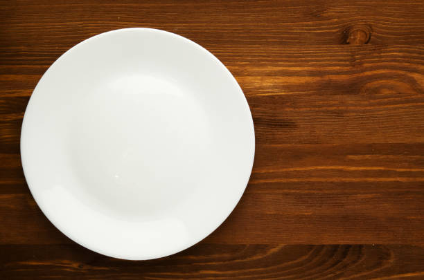 istock plate on a wooden background. plate top view. copy space .white plate 641675224