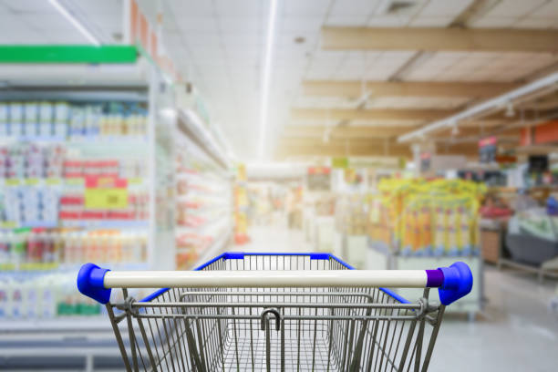istock Supermarket aisle with empty blue shopping cart 641675368
