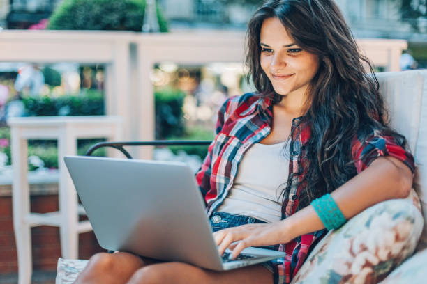 istock Beautiful young woman using laptop in the evening 641675626