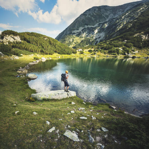 istock Traveler standing at the lake in mountains 641677134
