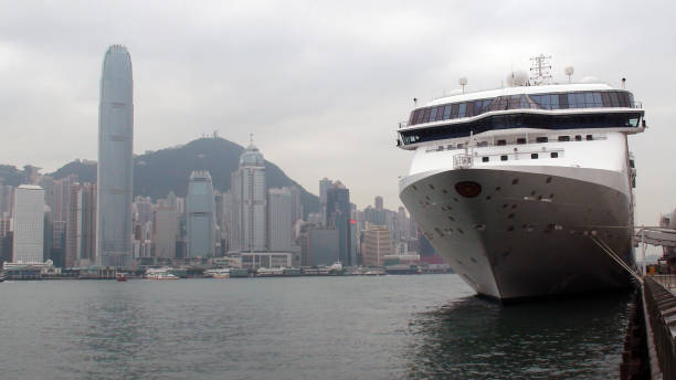 View Of Hong Kong Skyline,Sky,Boat On Victoria Harbour,Mountain,Star Cruises Cruise Ship Docked At Ocean Terminal In Kowloon Hong Kong China East Asia