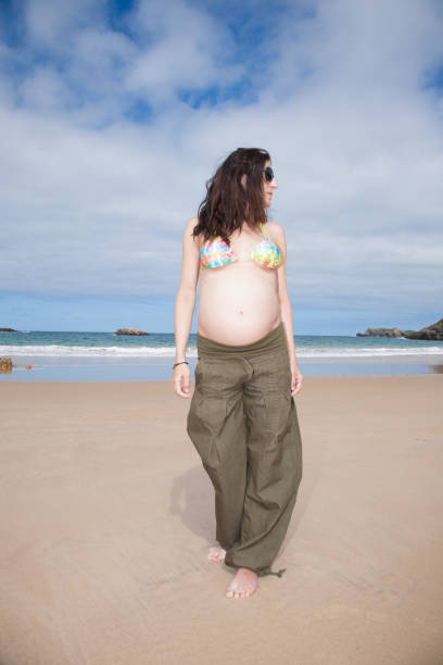 istock pregnant at beach looking aside 641680710
