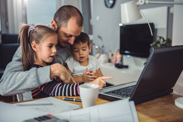 istock Father with daughter and son on his lap 641682462