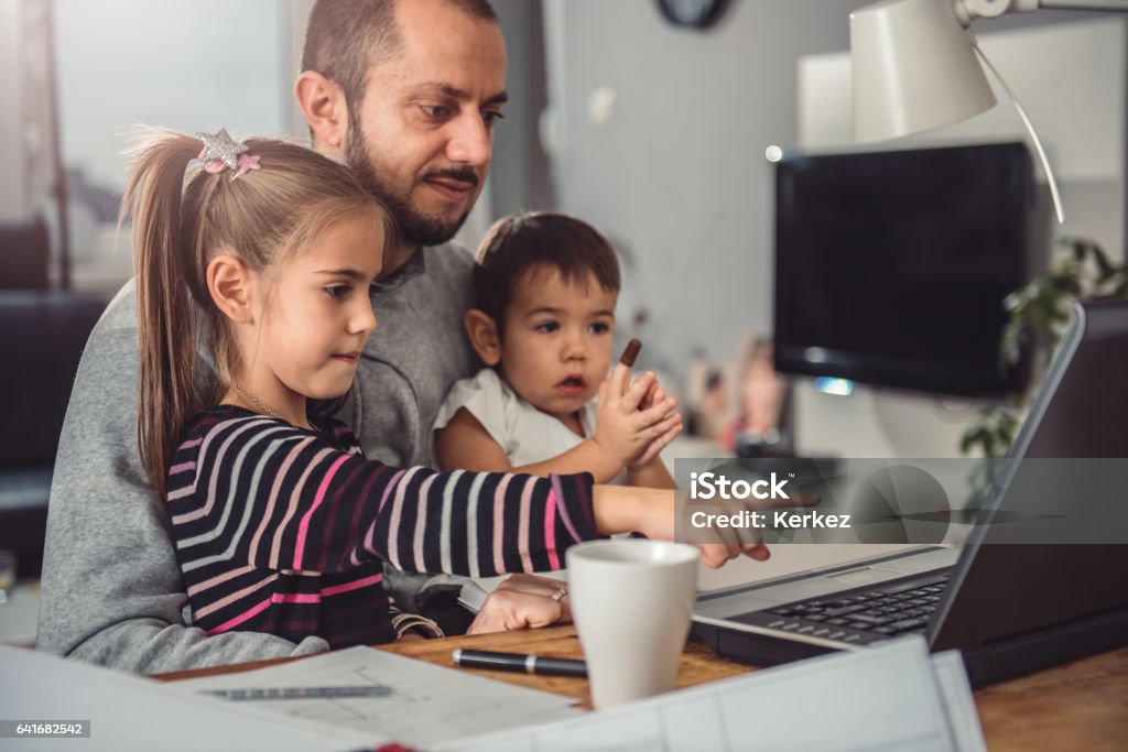 Father with daughter and son on his lap Father with daughter and son on his lap watching laptop Beard Stock Photo