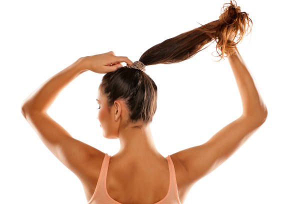 jeune femme attaché ses cheveux en queue de cheval - ponytail photos et images de collection