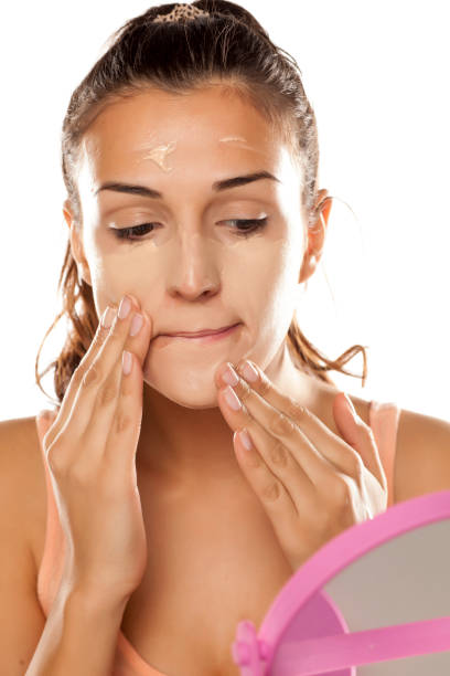 istock young woman applying a liquid foundation on her face 641684968