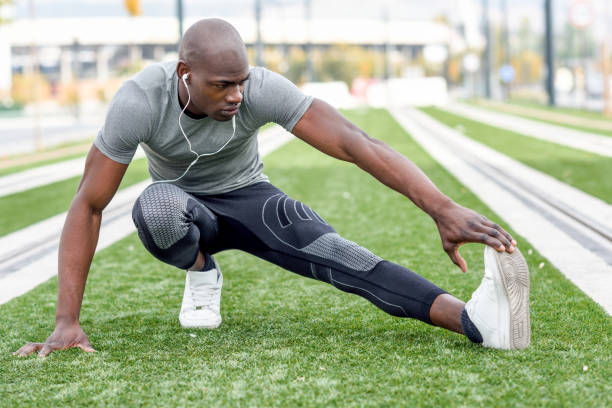 Black man doing stretching before running in urban background. stock photo