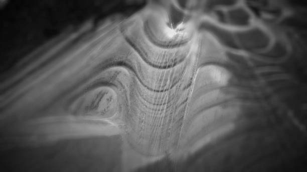 istock Frozen Ice Puddle Ripples Black and White Background Close Up 641693650