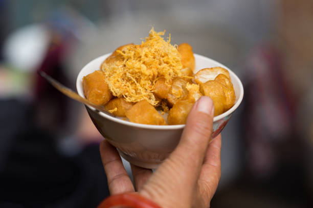 bowl of finger - shaped soufle’ porridge on woman hand. vietnamese food - clayton imagens e fotografias de stock