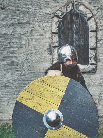 photography of a medieval knight in dark armor, holding an axe and a mace