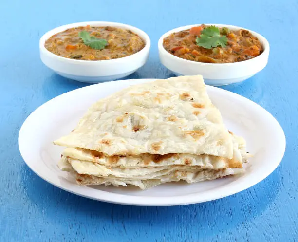 Indian food naan, a type of traditional and popular bread, and vegetable curries.