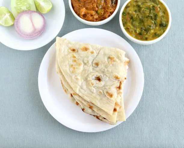 Indian food naan, a type of traditional and popular bread, vegetable curries and salad.