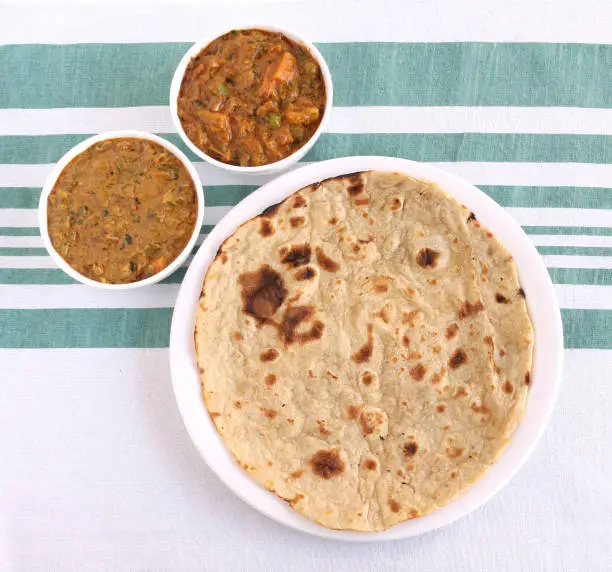 Indian food roti, a traditional and popular bread made from wheat flour dough, and two vegetable curries as side dishes.