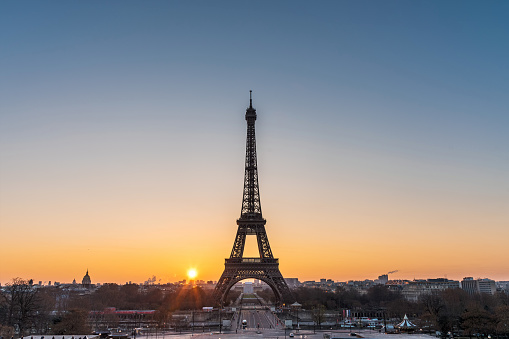 Landscape view of a warm sunrise over Paris and the Eiffel tower with a beautiful orange to blue gradient color