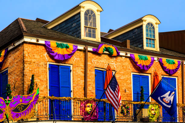 Photo of facades with colorful flags and decorations during the Mardi Gras festival on Bourbon Street in the French Quarter of New Orleans, Louisiana, USA.