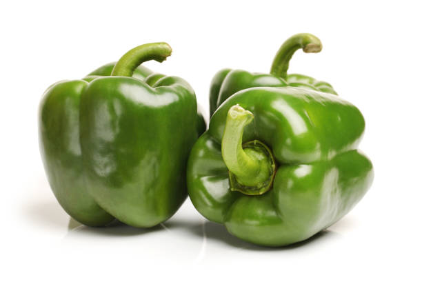 istock Two green bell peppers isolated on a plain white background 641719554