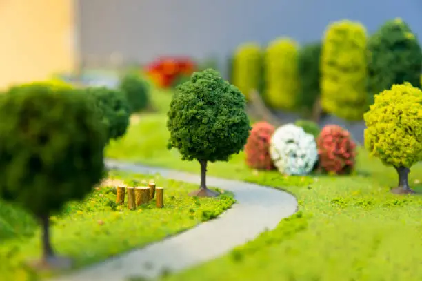 miniature landscape of a park with trees a small  road and grass. Selective focus.