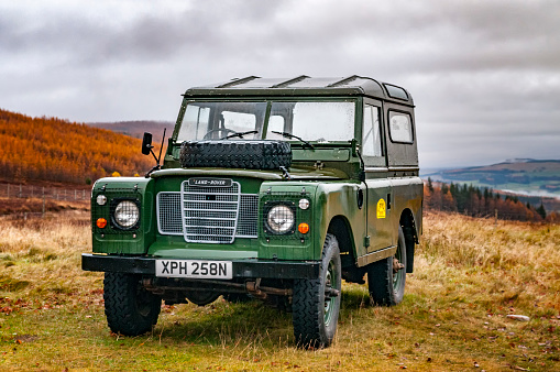 Old Land Rover Defender parked on a mountain in the Scottish Highlands near the town of Pitlochry during Autumn.