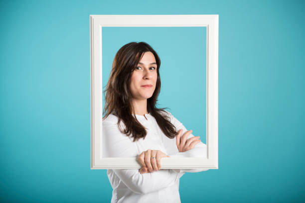istock happy smiling woman posing with a picture frame 641720758