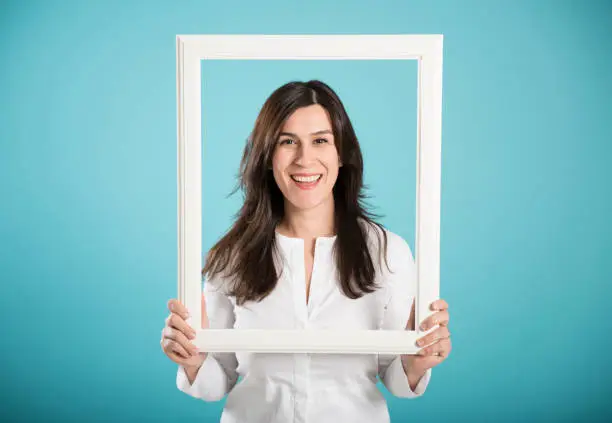 Photo of happy smiling woman posing with a picture frame
