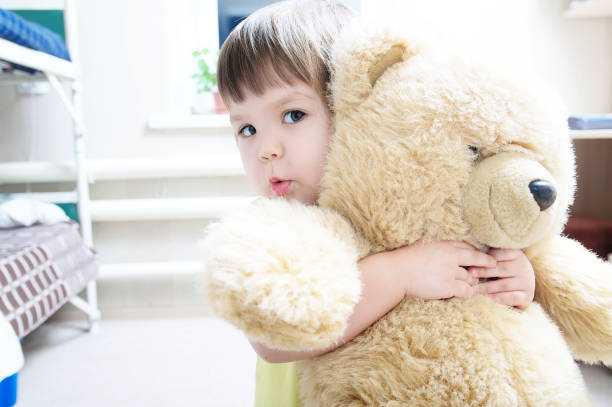 istock child hugging teddy bear indoor in her room, devotion concept,big bear toy 641722650