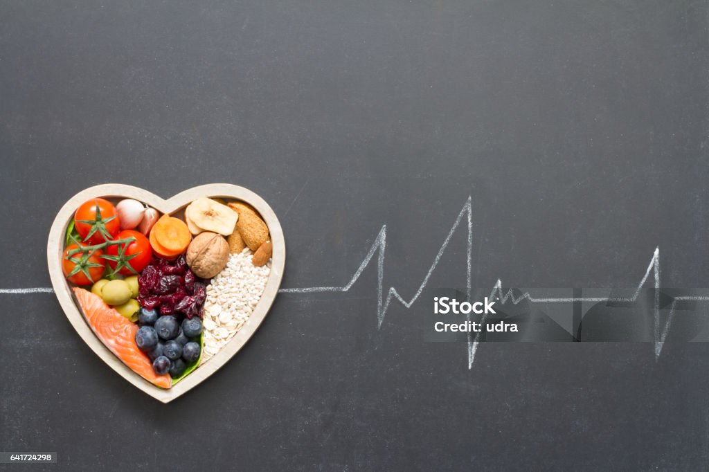 Healthy food in heart and cardiograph on blackboard medical abstract Healthy food in heart and cardiograph on blackboard medical abstract concept Cholesterol Stock Photo