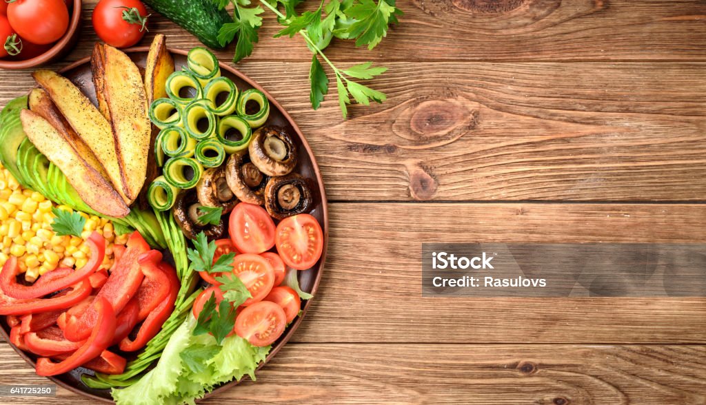 Buddha bowl of mixed vegetable on the wooden table. Avocado Stock Photo