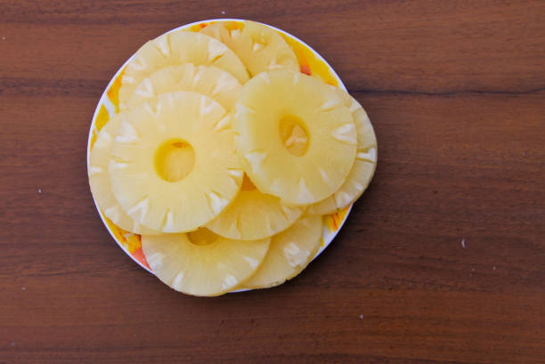 istock Canned pineapple on a plate on wooden table 641725554
