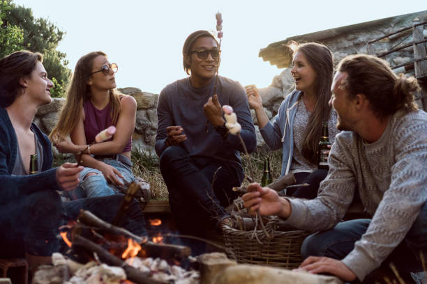 istock Happy friends roasting marshmallows at beach 641730678