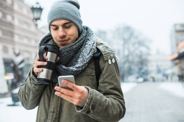 Young man walking down the street and checking cellphone