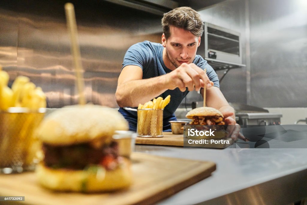 Koch bereitet Burger auf Teller im restaurant - Lizenzfrei Kochberuf Stock-Foto