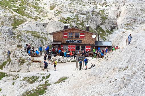 Sexten, Italy - August 2, 2016: People at alpine Hut Büllelejochhütte in Sexten Dolomites. The Büllelejochhütte is a private hut and is located at an altitude of 2528 m.