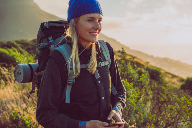 istock Smiling female hiker holding phone on mountain 641732478