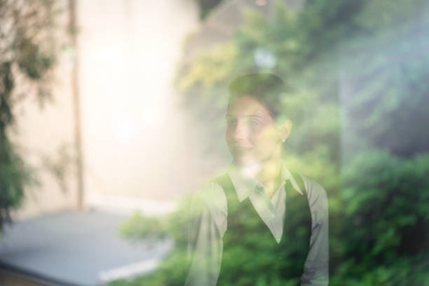 Thoughtful female entrepreneur seen through window