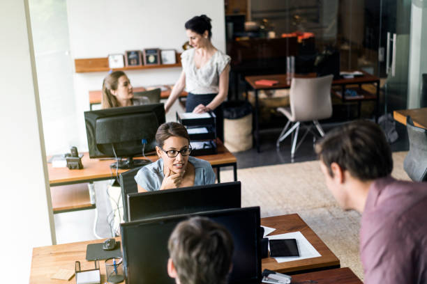 istock Colleagues are communicating at desks in office 641732580