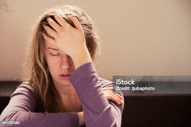 Woman Suffering From Stress Or A Headache Grimacing In Pain Stock Photo - Download Image Now