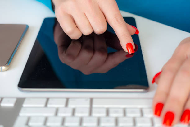 Woman working on her smartphone and tablet behind pc