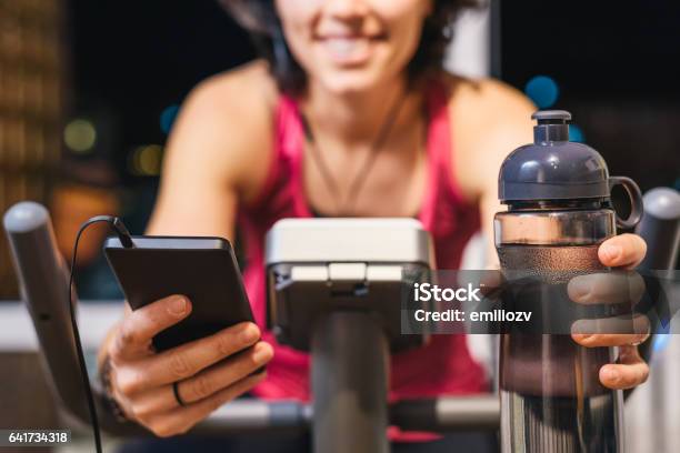 Healthy Fit Smiling Woman Training At Home On Exercise Bike Stock Photo - Download Image Now