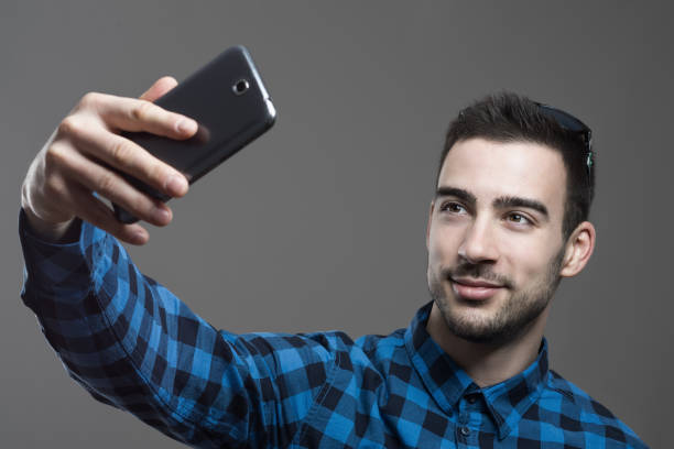 istock Confident flirty young man taking high angle selfie portrait 641735288