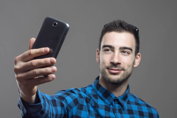 istock Young confident happy man taking self portrait with mobile phone 641735464